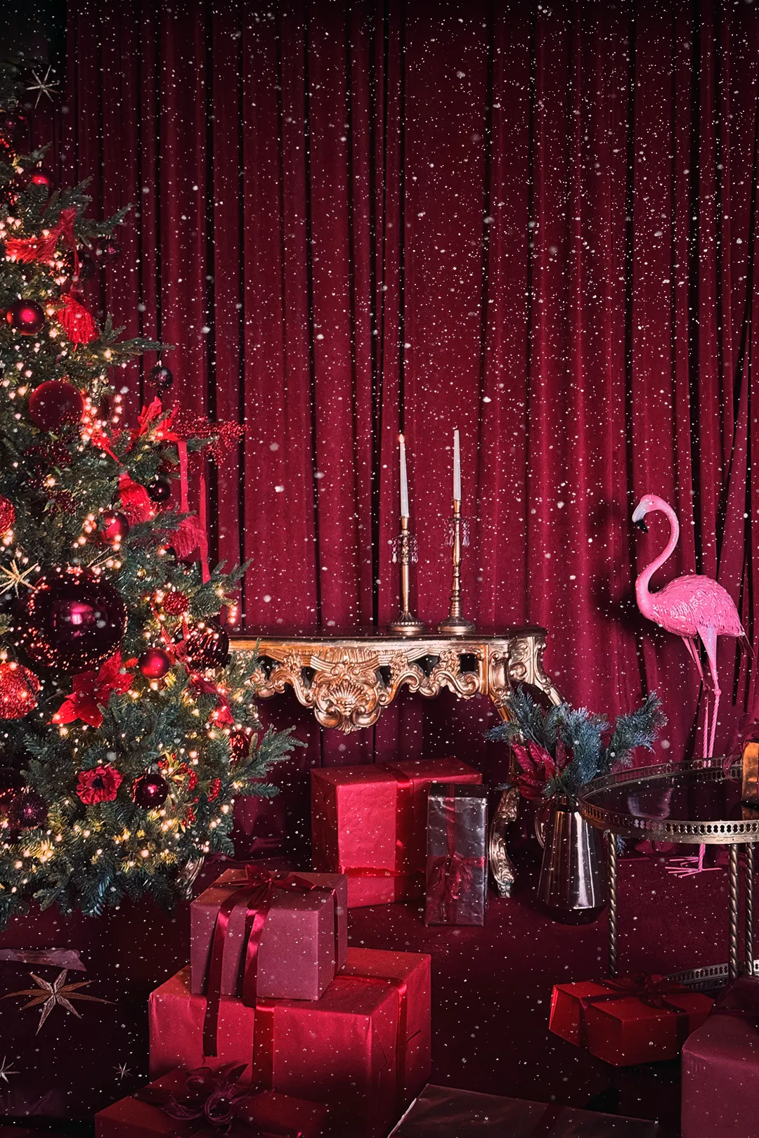 Christmas set with burgundy curtains, a decorated tree, red gifts and a pink flamingo at Luma Studio Dubai.